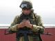 Военный-десантник держит в руках смартфон. Фото: Олег Харсеев / Коммерсант